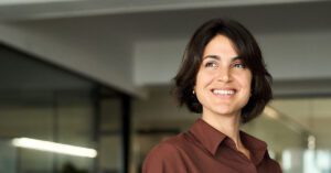 Blogs 9 Confident female financial advisor smiling in a modern office, representing the value of active wealth management powered by Financial Gravity.