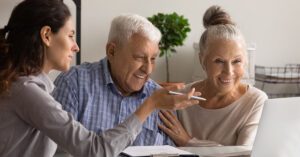 Blogs 3 Smiling senior couple meeting with a financial advisor, reflecting world-class client service enabled by Financial Gravity’s support solutions.