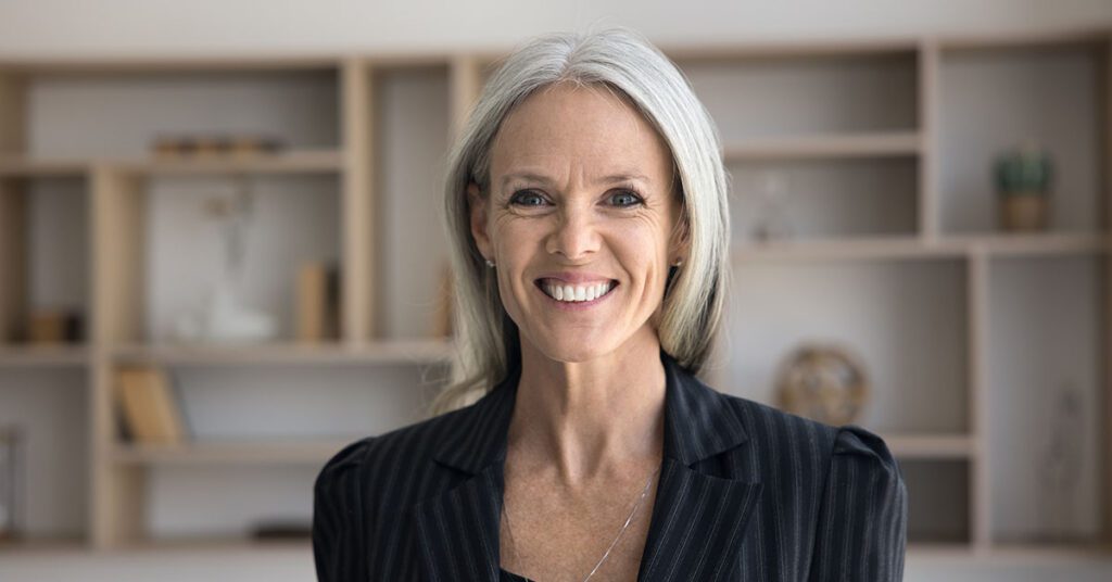 Experienced financial advisor smiling confidently, representing the freedom and growth possible with Financial Gravity’s support.
