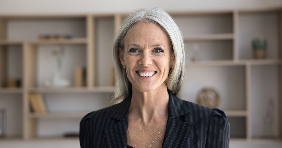 Experienced financial advisor smiling confidently, representing the freedom and growth possible with Financial Gravity’s support.