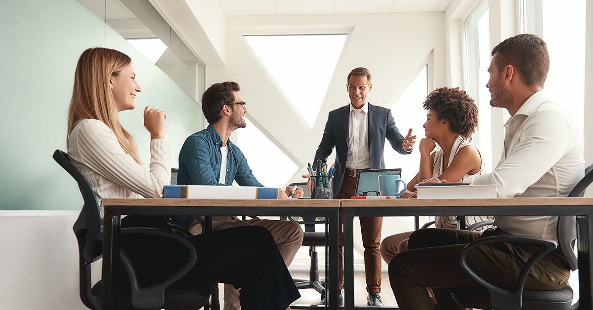 Financial advisory team collaborating in a bright modern office, symbolizing the power of human synergy in an AI-enhanced environment.