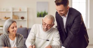 Financial Gravity enables financial advisors to coordinate multigenerational planning, shown by an advisor guiding an older couple as they sign estate documents.