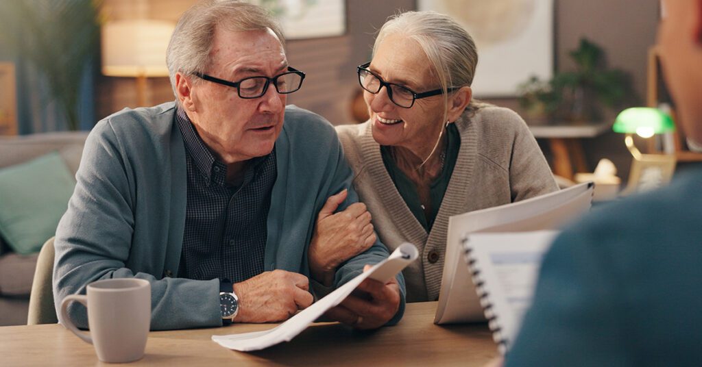 Financial Gravity empowers financial advisors to prompt action, shown by an older couple reviewing documents in a planning meeting.
