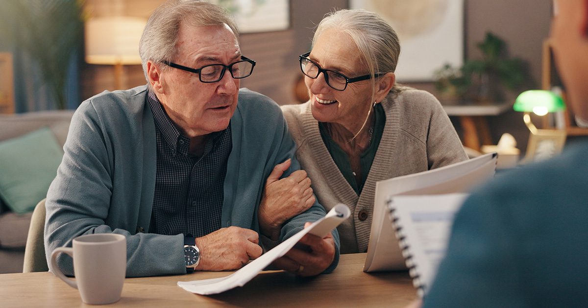 Financial Gravity empowers financial advisors to prompt action, shown by an older couple reviewing documents in a planning meeting.