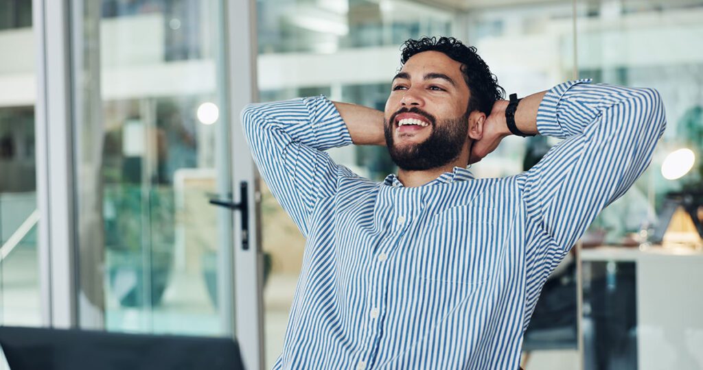 A confident financial advisor relaxes in his office after streamlining operations through Financial Gravity’s multi-family office solutions.