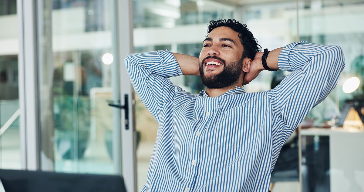 A confident financial advisor relaxes in his office after streamlining operations through Financial Gravity’s multi-family office solutions.