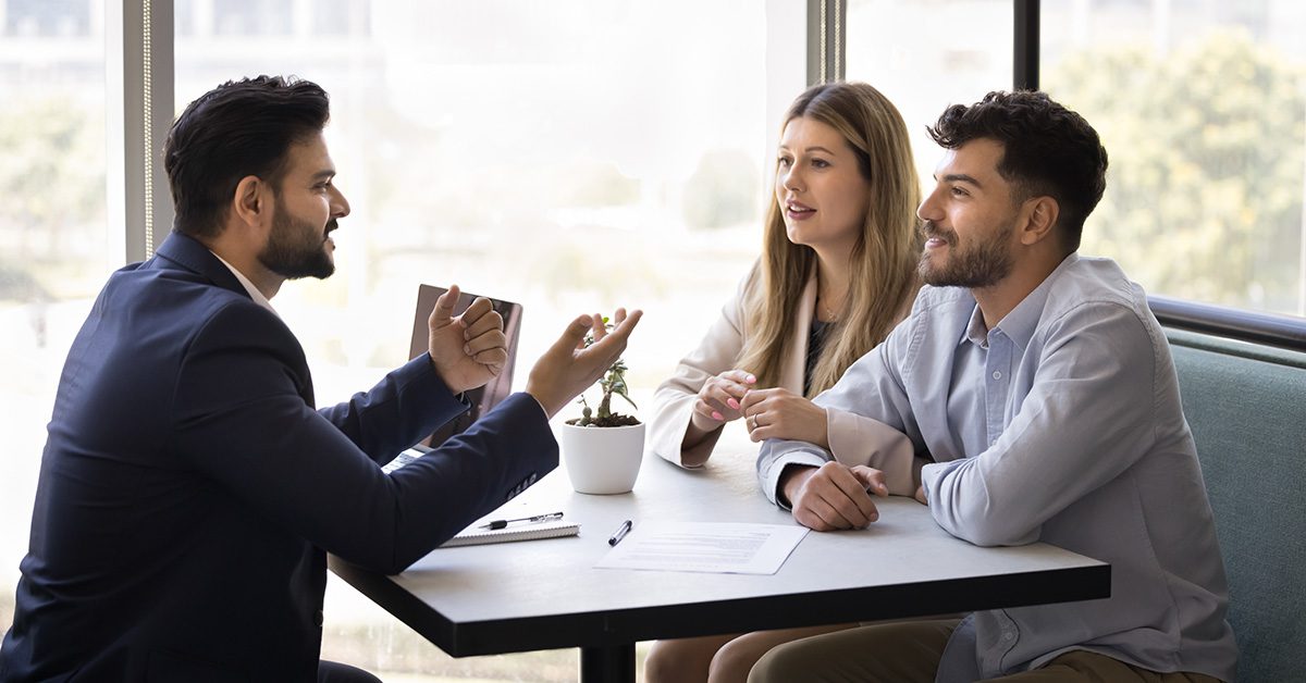 A financial advisor meets with a young couple, discussing how to align their wealth with family values and long-term purpose.