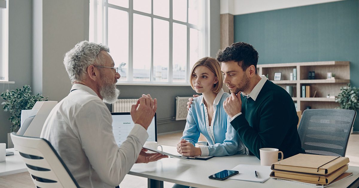 A financial advisor meets with a couple to explain financial strategies, focusing on clarity, alignment, and shared decision-making.