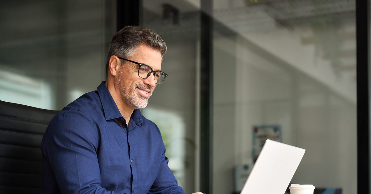 A financial advisor works focused at a laptop in a quiet office, reviewing priorities during a dedicated block of uninterrupted time.
