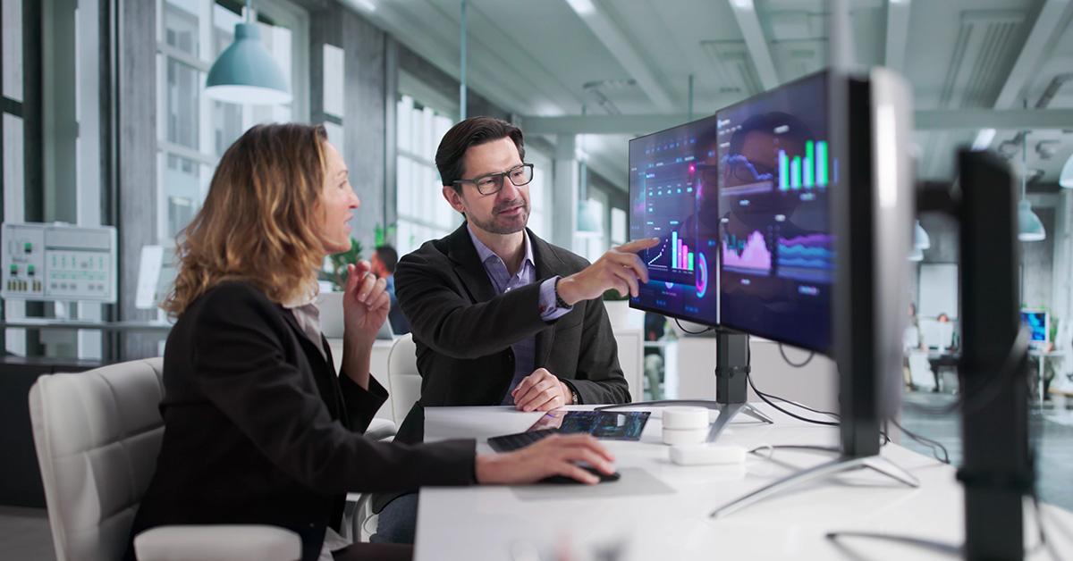 A financial advisor reviews long-term financial performance with a client while using modern analytics to support strategic planning.